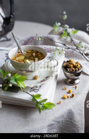 Kamillentee – Antike Teetasse mit Kräutertee Stockfoto