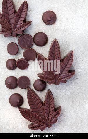 CBD-Pralinen. Köstliche stimmungsvolle Speisen, Desserts und Leckereien mit dem gewissen etwas. Dunkle Schokolade auf grauem Hintergrund Stockfoto