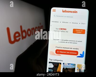 Person mit Zellphoe und Webseite des französischen Anzeigenunternehmens Leboncoin auf dem Bildschirm vor dem Logo. Konzentrieren Sie sich auf die Mitte des Telefondisplays. Stockfoto