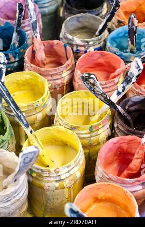 Große Gruppe offener alter, dreckiger Dosen mehrfarbiger Farben, vertikales Erntegut, abstrakter künstlerischer Hintergrund Stockfoto