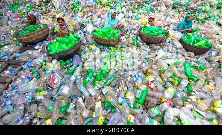 Dhaka, Bangladesch. 19. Juli 2023, Dhaka, Dhaka, Bangladesch: Arbeiter sortieren gebrauchte Plastikflaschen in einer Recyclingfabrik in Dhaka, Bangladesch. Die Mitarbeiter tragen dazu bei, zu verhindern, dass die Flaschen entsorgt, auf Deponien entsorgt, wo es 1.000 Jahre dauern kann, bis sie biologisch abgebaut sind, oder verbrannt werden, wodurch giftige Dämpfe entstehen. Da die Hauptstadt von Bangladesch, Dhaka, eine der am dichtesten besiedelten Regionen der Welt ist und fast 19 Millionen Menschen beheimatet, ist der jährliche Plastikverbrauch von Dhaka pro Kopf mehr als dreimal so hoch wie der nationale Durchschnitt für städtische Gebiete und liegt bei 22,25 kg. Kredit: ZUMA Press, Inc./Alamy Live News Stockfoto