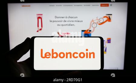 Person, die ein Smartphone mit dem Logo des französischen Anzeigenunternehmens Leboncoin auf dem Bildschirm vor der Website hält. Konzentrieren Sie sich auf das Display des Telefons. Stockfoto