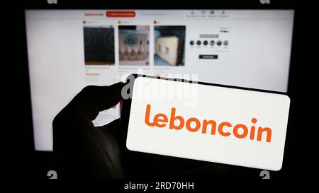 Person, die ein Handy mit dem Logo des französischen Unternehmens Leboncoin auf dem Bildschirm vor der geschäftlichen Webseite hält. Konzentrieren Sie sich auf das Display des Telefons. Stockfoto