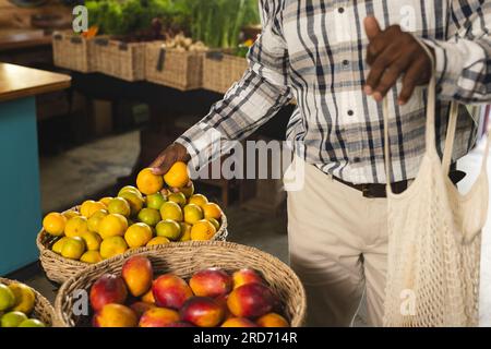 Ein afroamerikaner mit Zitronen, Einkaufen im Bio-Lebensmittelgeschäft Stockfoto
