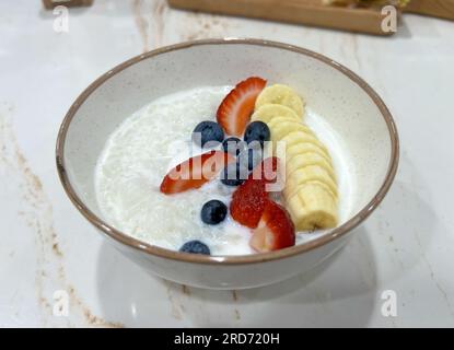 Reisbrei mit Banane, Erdbeere und Heidelbeere Stockfoto