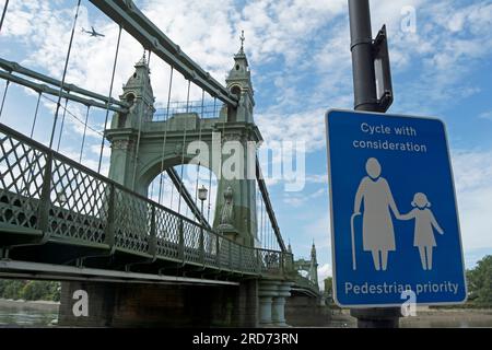 Blauer und weißer Fahrzyklus mit Bedacht, Fußgängerschild neben der hammersmith-Brücke an der themse in hammersmith, london, england Stockfoto