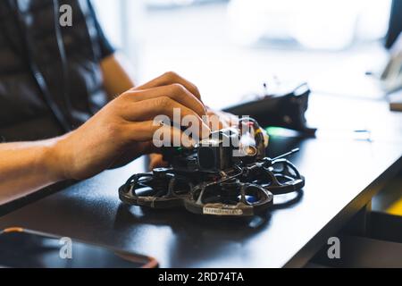 Unbekannter Mann, der FPV-Drohne im Laden angeschaltet hat, professionelle Fotografie. Hochwertiges Foto Stockfoto