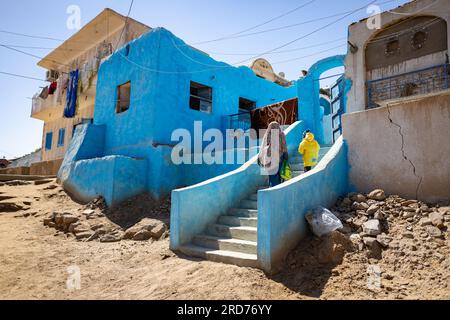 Eine Mutter und ein Kind gehen die Treppe hinauf zu ihrem Haus in einem nubischen Dorf in Assuan, Ägypten. Stockfoto