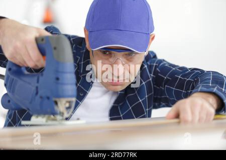 Veraltete Fachfirma mit Elektrostichsäge Stockfoto