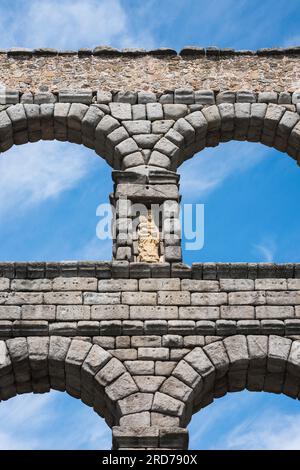 Spanien römisches Aquädukt, Detail des oberen Steinwerks des römischen Aquädukts in Segovia mit einer Statue der Jungfrau Maria in einer Nische, Spanien Stockfoto