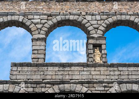 Spanien römisches Aquädukt, Detail des oberen Steinwerks des römischen Aquädukts in Segovia mit einer Statue der Jungfrau Maria in einer Nische, Spanien Stockfoto