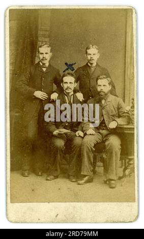 Rückseite der viktorianischen CDV-Gruppe (Carte de Visite oder Visitenkarte) von vier Männern, möglicherweise Freunde in Anzügen, Schnurrbart, aus dem Studio von Geo (George) Berry, 445 Southwark Park Road, Bermondsey, S.E. London, Großbritannien um 1880 bis 1886. Stockfoto