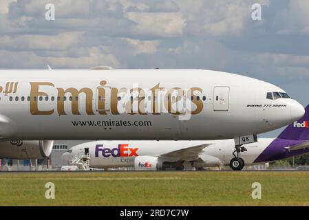 A6-EQK Emirates Boeing 777-31H(er) mit N852FD FedEx Express Boeing 777-FS2 hinten. Stockfoto