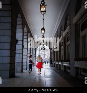 Attraktives blondes Mädchen in rotem Rock vor dem Ritz Hotel in London Stockfoto