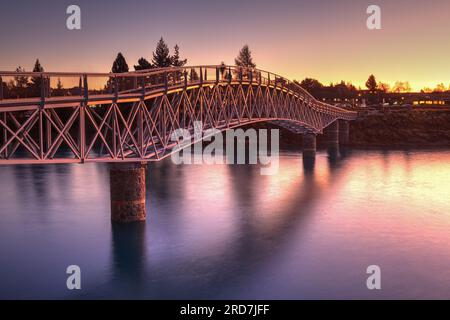 Tekapo-See, Neuseeland. Die Maclaren Fußgängerbrücke über den Tekapo River, bei Sonnenuntergang zu sehen Stockfoto