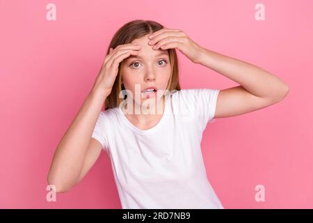 Portrait von beeindruckten traurigen Mädchenarmen Finger berühren zerdrückte Stirnpickel isoliert auf pinkfarbenem Hintergrund Stockfoto