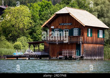 Wunderschönes traditionelles Holzhaus über dem Wasser an einem spektakulären Weissensee in Kärnten in Österreich, Wasser im karibischen Stil Stockfoto