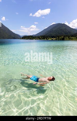 Kindertourist genießt Schulferien an einem spektakulären Weissensee in Kärnten in Österreich, karibisches Wasser an einem schönen sonnigen Sommertag Stockfoto