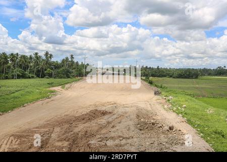 Tiaong, Philippinen. 19. Juli 2023: Laufende Arbeiten an einem der größten philippinischen Projekte. Brücken und Straßen durchqueren Reisfelder und Wälder. Die South Luzon Expressway toll Road 4 (SLEX TR4) ist Teil des längsten Autobahnprojekts des Landes, das Manila zunächst mit Lucena und dann mit dem 2022 unterzeichneten Projekt SLEX TR5 nach Matnog verbinden wird. Die die Provinzen Quezon und Bicol über eine 420 km lange Mautstraße miteinander verbinden. Am Dienstag unterzeichnete Pres. Marcos ein Gesetz über Staatsfonds im Wert von $9 Milliarden US-Dollar, mit dem Wirtschaftswachstum, Straßen und Infrastruktur gefördert werden sollen. Kredit: Kevin Izorce/Alamy Live News Stockfoto