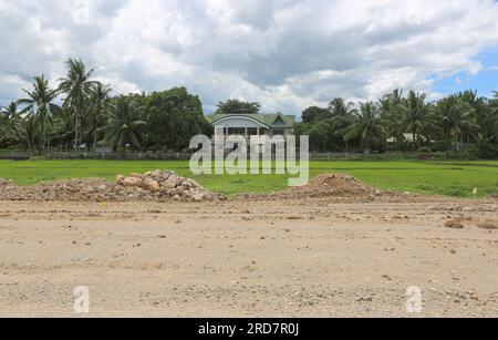 Tiaong, Philippinen. 19. Juli 2023: Laufende Arbeiten an einem der größten philippinischen Projekte. Ein abgelegenes Haus in den Reisfeldern, das jetzt neben der Schnellstraße liegt. Die South Luzon Expressway toll Road 4 (SLEX TR4) ist Teil des längsten Autobahnprojekts des Landes, das Manila zunächst mit Lucena und dann mit dem 2022 unterzeichneten Projekt SLEX TR5 nach Matnog verbinden wird. Die die Provinzen Quezon und Bicol über eine 420 km lange Mautstraße miteinander verbinden. Kredit: Kevin Izorce/Alamy Live News Stockfoto