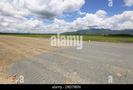 Tiaong, Philippinen. 19. Juli 2023: Laufende Arbeiten an einem der größten philippinischen Projekte. Brücken und Straßen durchqueren Reisfelder und Wälder. Die South Luzon Expressway toll Road 4 (SLEX TR4) ist Teil des längsten Autobahnprojekts des Landes, das Manila zunächst mit Lucena und dann mit dem 2022 unterzeichneten Projekt SLEX TR5 nach Matnog verbinden wird. Die die Provinzen Quezon und Bicol über eine 420 km lange Mautstraße miteinander verbinden. Am Dienstag unterzeichnete Pres. Marcos ein Gesetz über Staatsfonds im Wert von $9 Milliarden US-Dollar, mit dem Wirtschaftswachstum, Straßen und Infrastruktur gefördert werden sollen. Kredit: Kevin Izorce/Alamy Live News Stockfoto