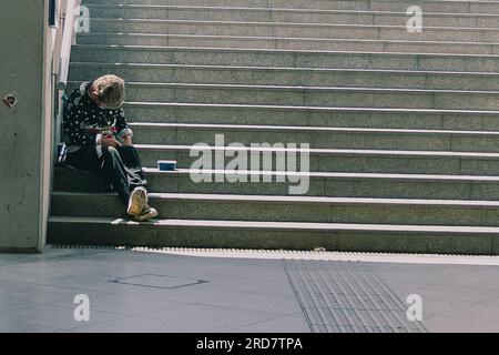 Ein Obdachloser, der auf der Treppe saß. In Ungarn, insbesondere in Budapest, herrscht anhaltende Besorgnis über Obdachlosigkeit. Aufgrund der hohen Inflation ist die Zahl der Menschen, die auf den Straßen leben, in der Stadt gestiegen. Faktoren wie Armut, Arbeitslosigkeit, psychische Gesundheit und Mangel an bezahlbarem Wohnraum tragen zu dem Problem bei. Die ungarische Regierung und die lokalen Behörden haben verschiedene Maßnahmen zur Bekämpfung der Obdachlosigkeit ergriffen. Dazu gehören die Bereitstellung von Notunterkünften, soziale Dienste und Programme zur Wiedereingliederung in die Gesellschaft. Nichtregierungsorganisation Stockfoto