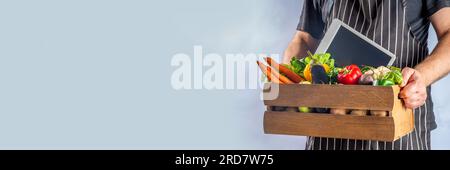 bauernmarkt-Shopping-Konzept, Holzkiste mit Sommer, rohem Gemüse und Obst im Herbst, in den Händen der bauernmänner auf weißem Hintergrund Stockfoto