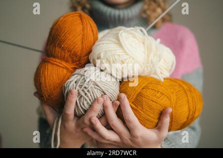 Frauenhände mit bunten Wollknäueln. Minimalistisches kreativmedizinisches Konzept Stockfoto