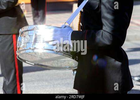 Die silberne Trommel in den Händen eines Musikers einer Militärband funkelt in der Sonne. Stockfoto