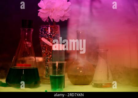 Wissenschaftlich-chemische Versuche mit Reagenzgläsern, farbigem Rauch und mehrfarbigen Lösungen. Stockfoto
