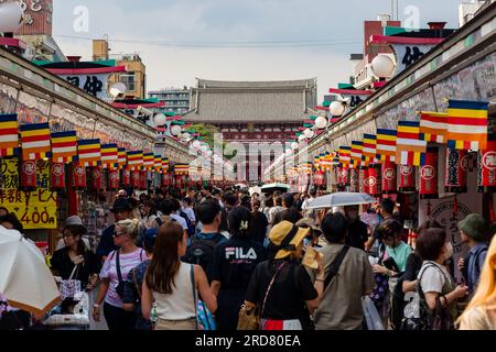 TOKIO, JAPAN - JULI 18 2023: Touristenmassen und Einheimische packen die Nakamise Dori Street in Richtung des Senso-ji Tempels in Asakusa, Tokio Stockfoto