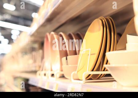 Geschirr auf einem Regal in einem Geschäft, selektiver Fokus. Platten auf unscharfem Hintergrund. Einkaufszentrum Stockfoto