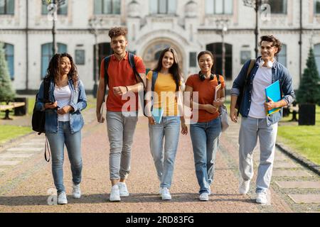 Eine Gruppe fröhlicher Studenten, die zusammen den Campus verlassen Stockfoto