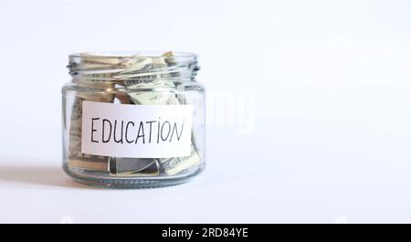 Glasbehälter mit Geld, Dollarscheine, weißer Hintergrund. Sparschwein mit Dollars für Bildung. Speicherplatz kopieren. Stockfoto