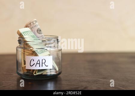 Glasbehälter mit Dollarscheinen drin. Bank mit Geld-Nahaufnahme. Sparschwein mit Dollars für das Auto. Sparen Sie Geld für die Zukunft Stockfoto