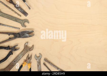 Flache Verlegung mit alten Werkzeugen auf hellem Holzhintergrund. Draufsicht mit verschiedenen Reparaturwerkzeugen. Das Konzept von Handwerkskunst und Handwerk, Fett Stockfoto