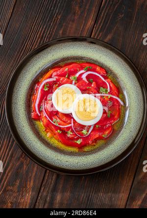 Zorongollo-Salat mit gebackenem Gemüsepaprika, Eiern, Zwiebeln und Tomaten Stockfoto