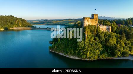 Polen. Mittelalterliche Burg in Niedzica, 14. Jahrhundert (oberer Teil) bei Sonnenuntergang. Künstlicher Zarensee am Dunajec-Fluss, verdammt und Wasserkraftwerk Stockfoto