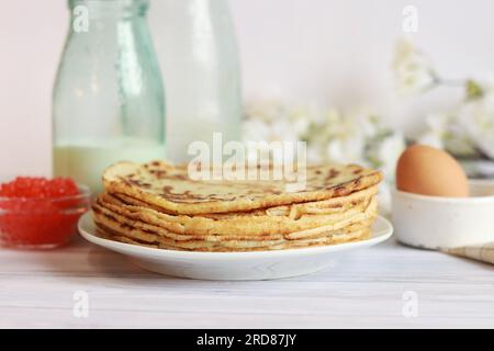 Ein Stapel dünner Pfannkuchen auf einem unscharfen Hintergrund. Selektiver Fokus. Eine Woche Crepes. Maslenitsa. Pfannkuchen aus der Nähe Stockfoto