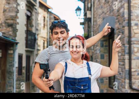 Ein junges Paar, das Vloggen und ein Video aufnimmt, während es ländlichen Tourismus in einem Bergdorf unternimmt. Urlaub und Sommerurlaub im Freien in Huesca, Spanien Stockfoto