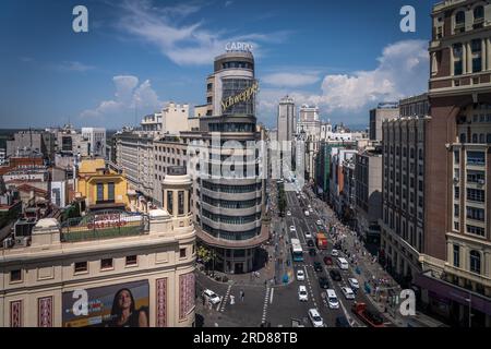 Die Gran Via in Madrid ist eine der geschäftigsten Einkaufsstraßen der Hauptstadt. Das berühmte Kapitol beherbergt ein Kino und ein Hotel. Stockfoto