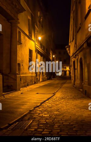 Stimmungsvolle Straße bei Nacht in der Nachbarschaft Le Marais, Paris, Frankreich Stockfoto