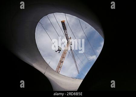 Stuttgart, Deutschland. 19. Juli 2023. Ein industrieller Bergsteiger arbeitet an einem Sicherheitsnetz eines Becherlagers des Bahnprojekts Stuttgart 21. Kredit: Marijan Murat/dpa/Alamy Live News Stockfoto