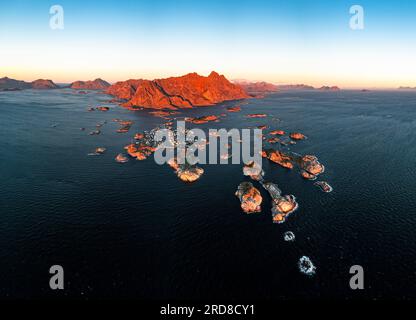 Panoramablick aus der Vogelperspektive auf das Fischerdorf Henningsvaer und die Berge bei Sonnenuntergang, Nordland County, Lofoten Islands, Norwegen, Skandinavien, Europa Stockfoto