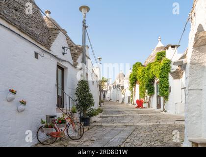 Weiß getünchte Trulli Häuser entlang der Straße in der Altstadt, UNESCO-Weltkulturerbe, Alberobello, Apulien, Italien, Europa Stockfoto