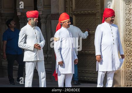 Jaipur, Indien -- Ein Teleobjektiv von Leguaren mit weißen Uniformen und roten Hüten im Stadtpalast von Jaipur. Stockfoto