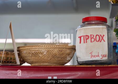 Eine Flasche mit einem Tipp-Box-Schild auf der Theke im Restaurant Stockfoto