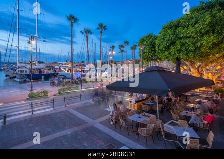 Blick auf Cafés und Boote im Hafen von Kos in der Abenddämmerung, Kos Stadt, Kos, Dodekanese, griechische Inseln, Griechenland, Europa Stockfoto