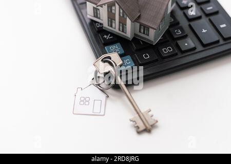Immobilien, Schlüsselanhänger mit Haussymbol. Schlüssel mit leerer Finanzierung. Stockfoto