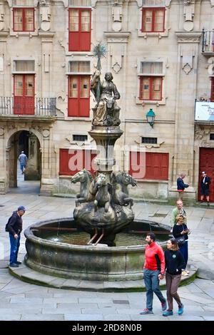 Frau, die einen Stern auf einer Marmor-Arche auf dem Pferdebrunnen vor der Casa do Cabido Praza de Praterías Santiago de Compostela Galicien Spanien erhebt Stockfoto